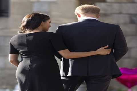 Sweet moment Meghan Markle comforts Prince Harry as he looks at floral tributes for the Queen