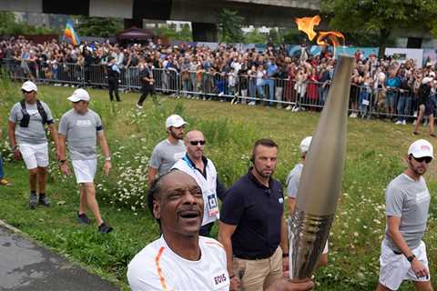 Snoop Dogg Carries Olympic Torch Through Paris Suburb